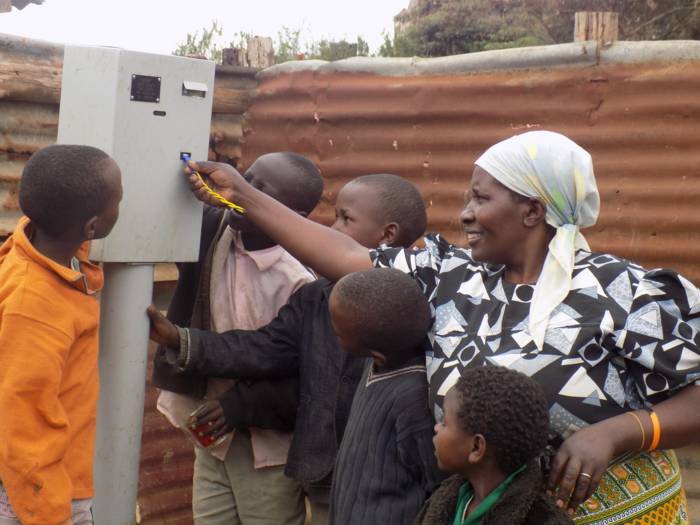Monica Wanjiru and children using water dispenser